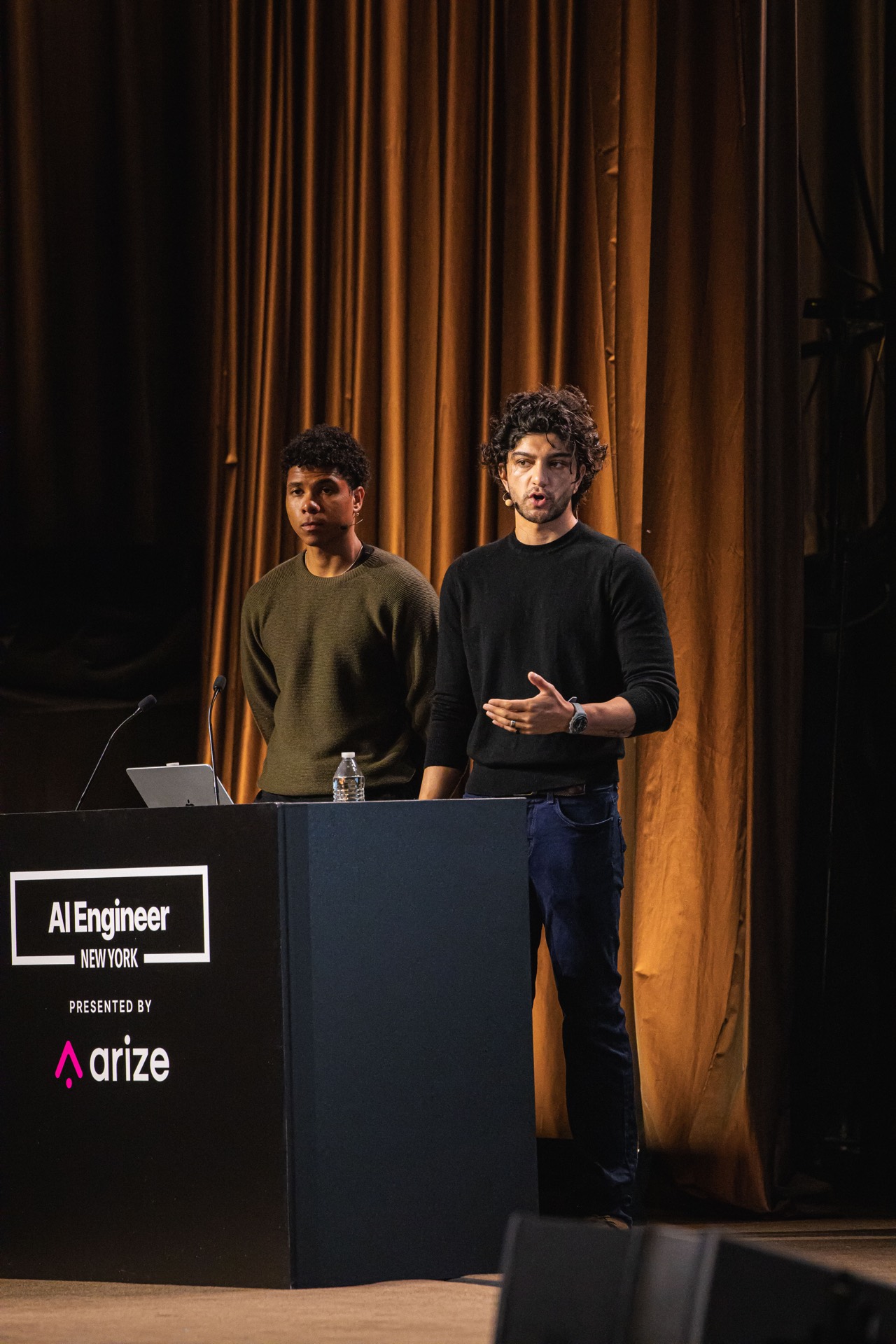 Affaan Mustafa speaking alongside Alejandro Soumah Fernandez at the AI Engineer NYC lectern.